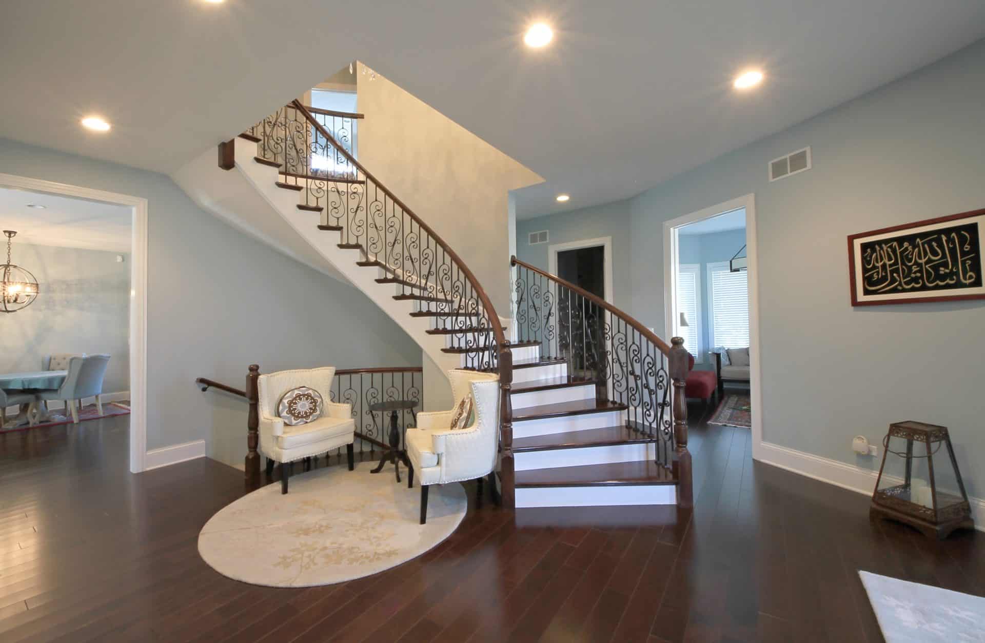 entry way with staircase and two white chairs